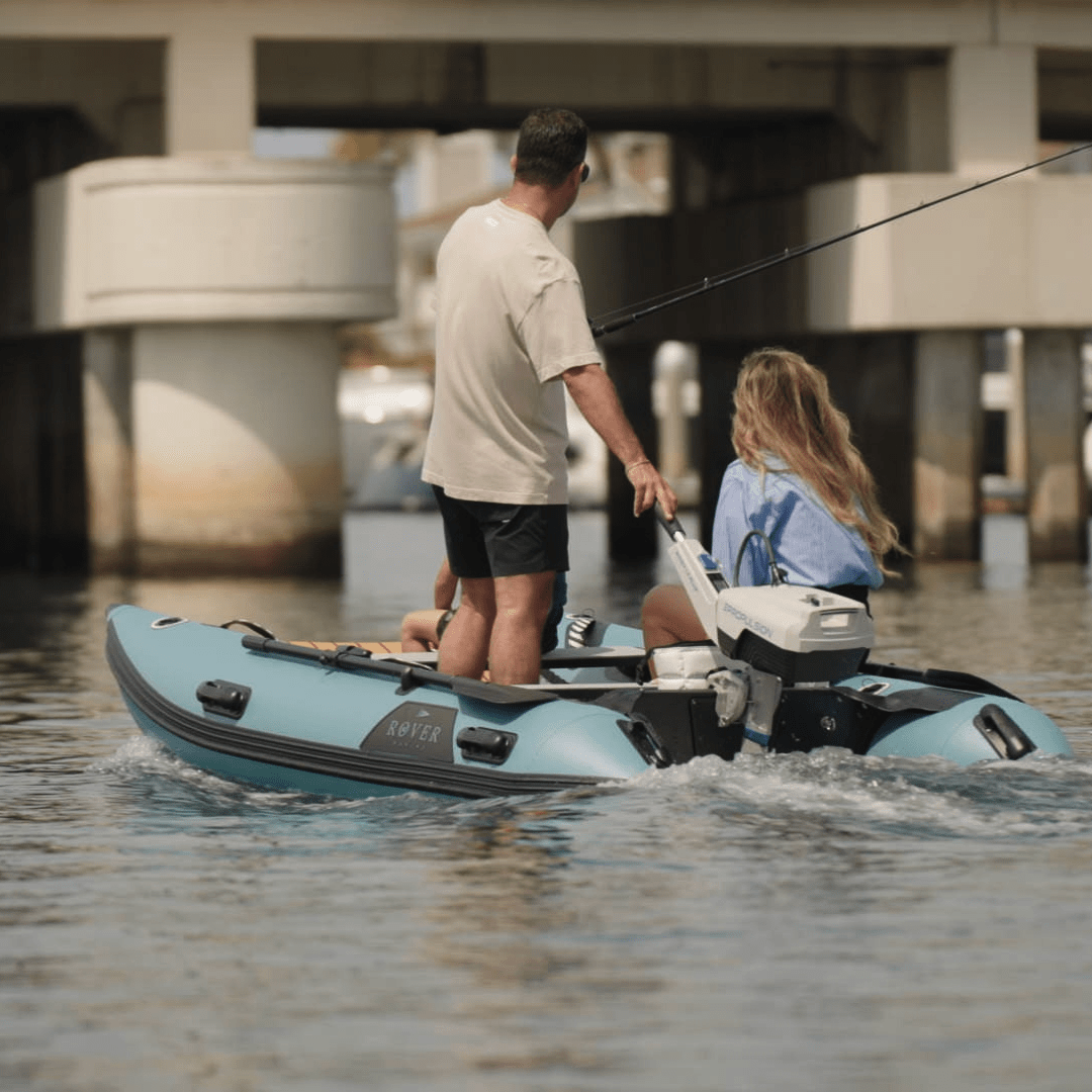 Couple fishing from a Rover Marine inflatable boat powered by an Epropulsion electric motor near a bridge.