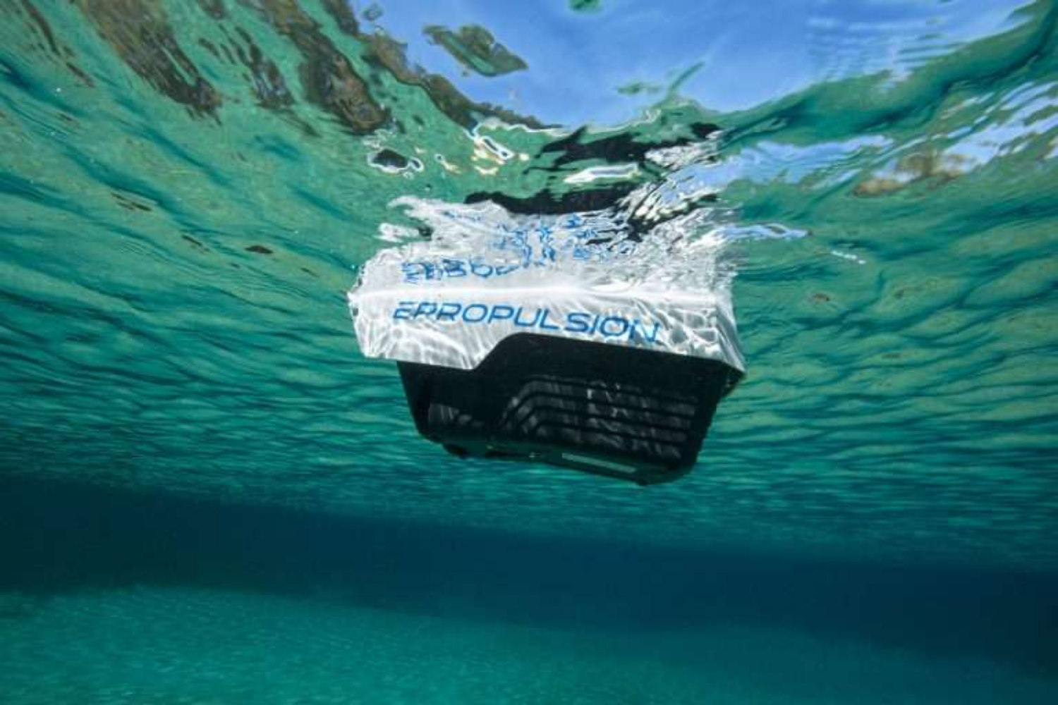 Underwater view of Epropulsion electric outboard motor in clear blue water.