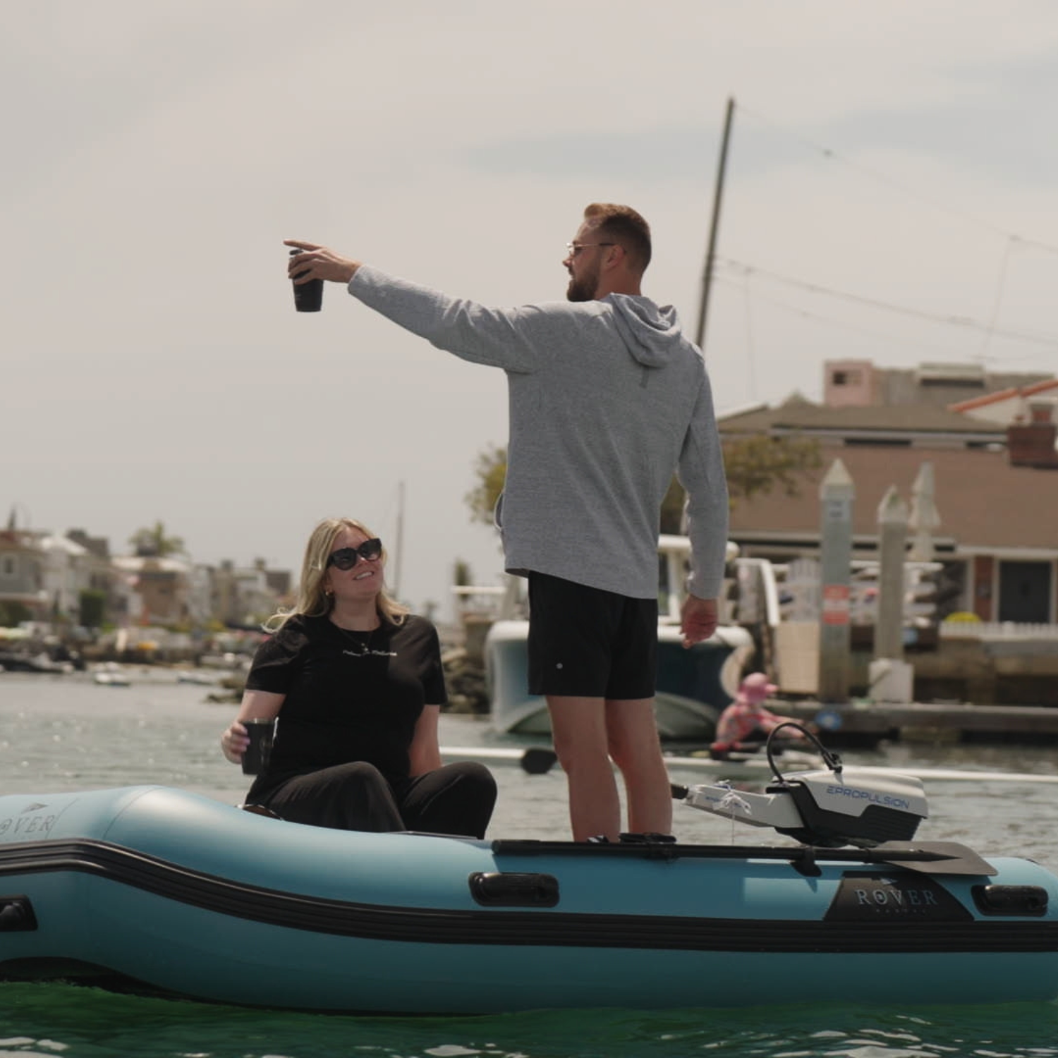 Couple enjoying a ride on a Rover Marine inflatable boat powered by an Epropulsion electric motor at the marina.